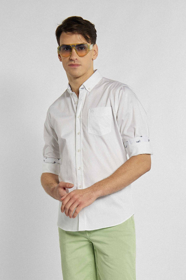 Chemise blanche avec poche poitrine, logo de la marque et motif floral
