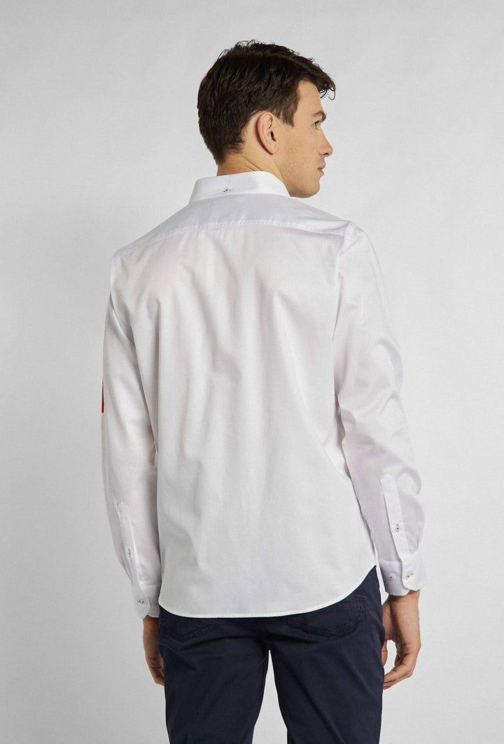 Chemise blanche avec lettrage de différentes couleurs sur la manche