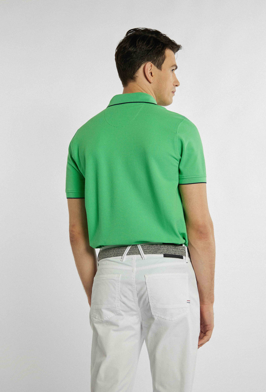 Groene polo met merklogo op de borst en zwarte fijne details