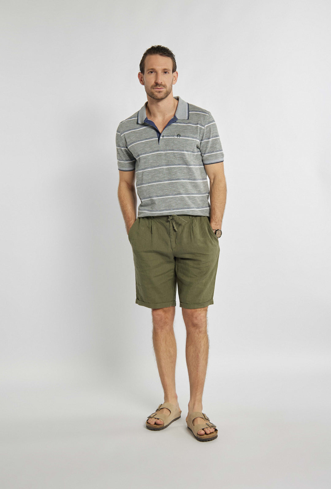 Gray polo shirt with navy and white stripes and brand logo on chest