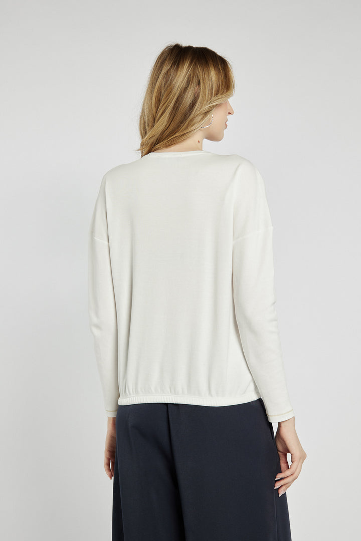 Light-colored blouse with decorative lettering on the front