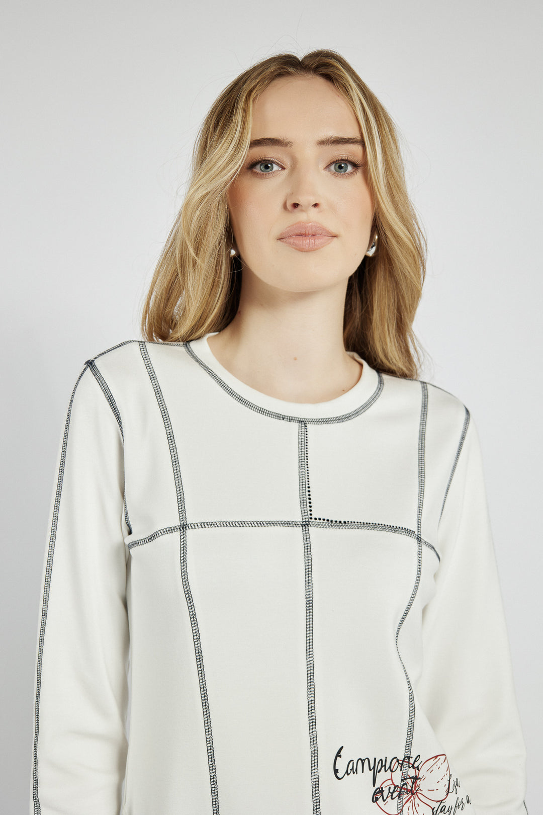 White sweatshirt with black stitching and graphics